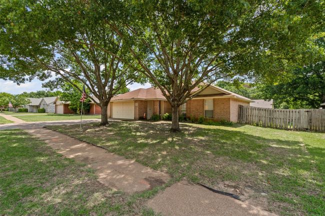 View of front facade featuring an attached garage, brick siding, and driveway | Image 5