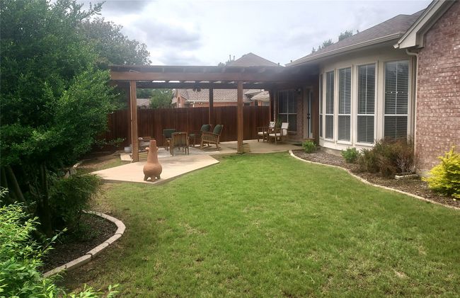 Spacious yard featuring a pergola covered patio area. | Image 31