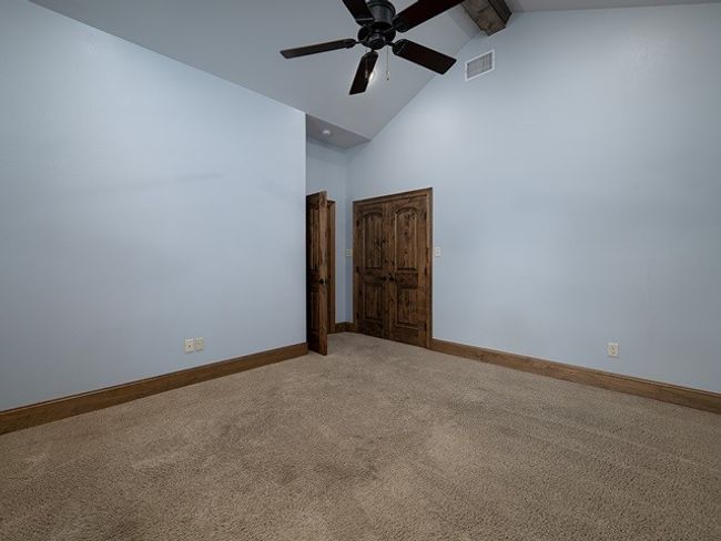 Carpeted spare room featuring high vaulted ceiling, baseboards, beamed ceiling, and visible vents | Image 25