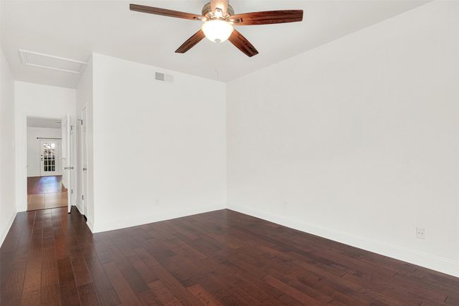 Spare room featuring dark wood finished floors, ceiling fan, and attic access | Image 16