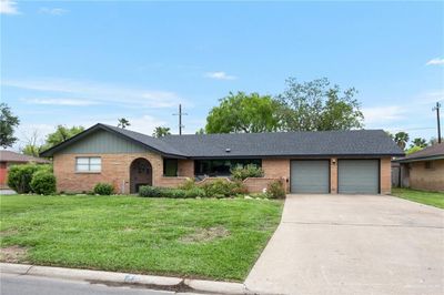 Ranch-style home with a garage and a front lawn | Image 1