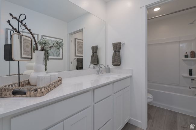 Full bath with vanity, shower / bathtub combination, and wood finished floors | Image 13