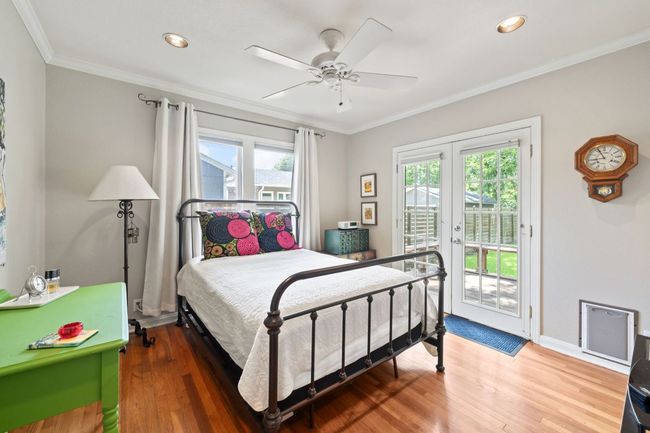 Bedroom featuring access to exterior, wood finished floors, ornamental molding, recessed lighting, and french doors | Image 7