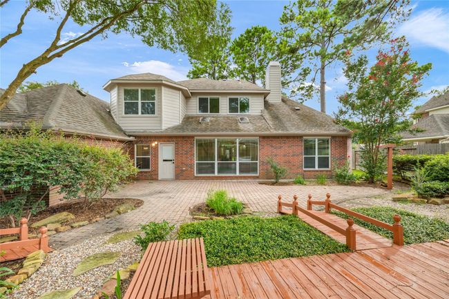 Meticulously maintained landscaping surrounds a spacious brick patio, perfectly suited for outdoor gatherings and peaceful relaxation within the garden-style layout. | Image 39