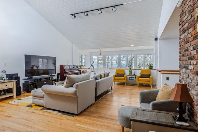 Living room with plenty of natural light, light wood-type flooring, and high vaulted ceiling | Image 6