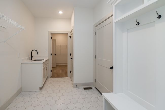 Laundry Room with Full Sink Cabinet, Mud bench, and direct primary suite access | Image 24
