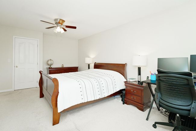 Carpeted bedroom featuring a desk and ceiling fan | Image 24