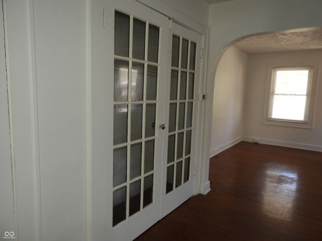 unfurnished room with baseboards, wood finished floors, arched walkways, and french doors | Image 4
