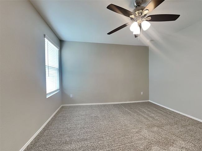 Unfurnished room featuring healthy amount of natural light, carpet flooring, ceiling fan, and baseboards | Image 6