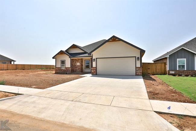 Craftsman-style house featuring brick siding, an attached garage, and driveway | Image 33