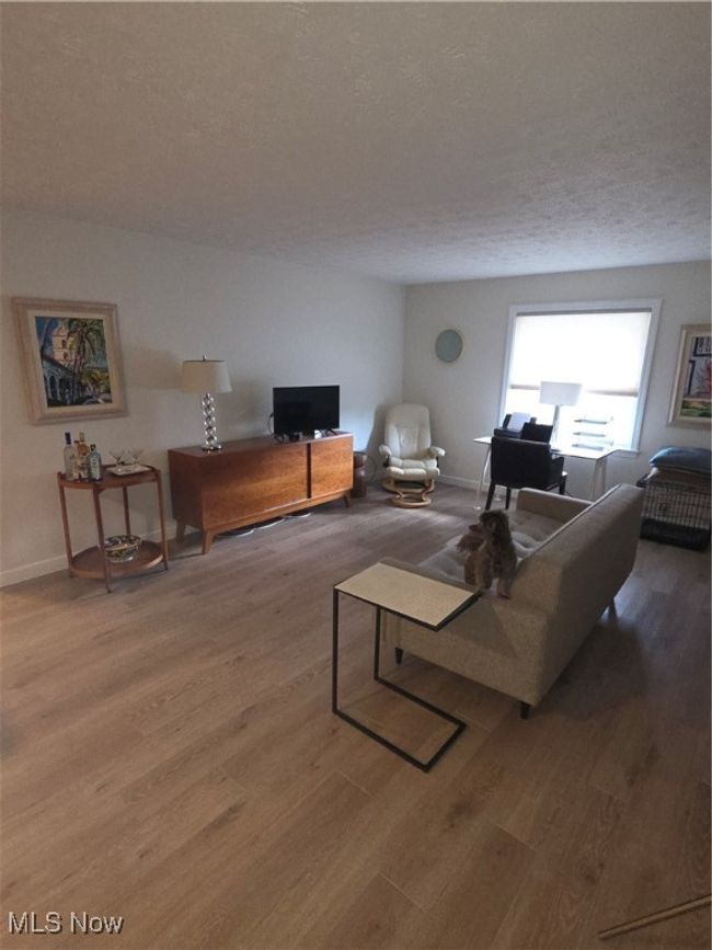 Living room with a textured ceiling, wood finished floors, and baseboards | Image 13