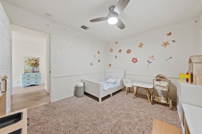 Bedroom with view to the hall entry, a ceiling fan and light carpet | Image 22