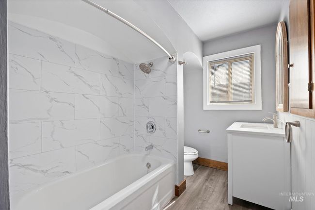 Full bath with vanity, wood finished floors, and shower / tub combination | Image 24