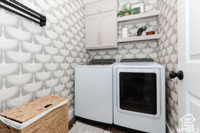 Laundry area with cabinet space, separate washer and dryer, and dark wood-style floors | Image 25