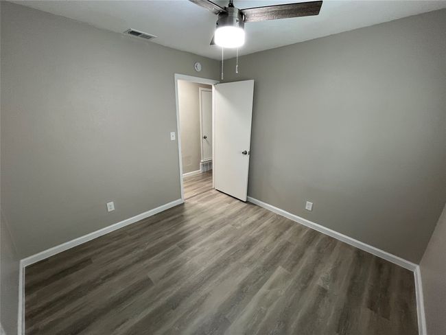 Spare room with wood finished floors, baseboards, and ceiling fan | Image 13