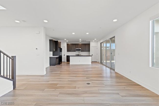 Unfurnished living room featuring baseboards, recessed lighting, stairs, and light wood finished floors | Image 25