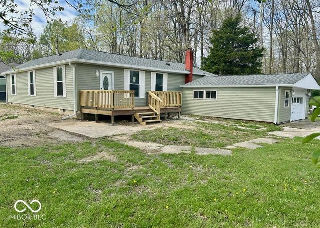 rear view of house with a chimney and a wooden deck | Image 6