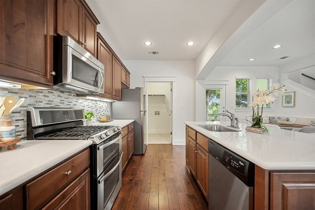 Stainless appliances include a gas range with 2 ovens, a built-in microwave and a dishwasher | Image 15