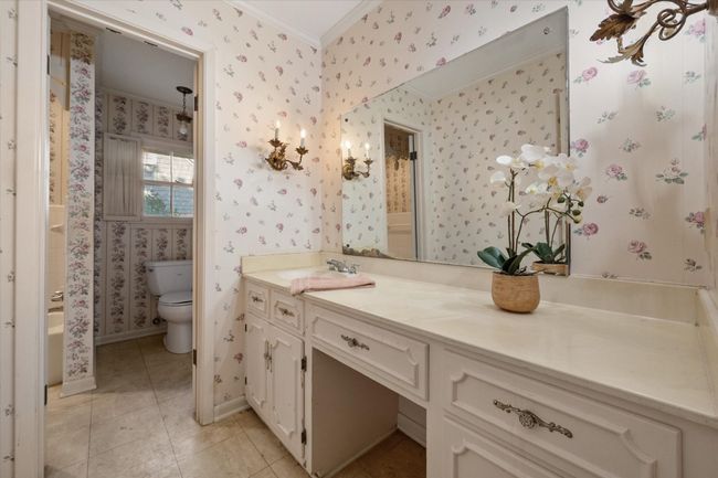 Bathroom with crown molding, wallpapered walls, vanity, and tile patterned flooring | Image 29