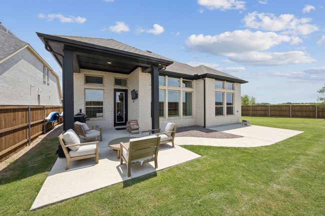 Back of house with a patio area, brick siding, roof with shingles, and an outdoor living space | Image 26