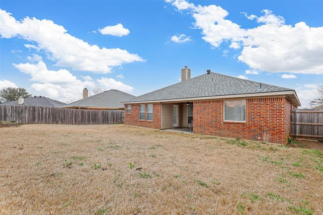 Back of house with a patio area, a fenced backyard, brick siding, and a lawn | Image 33