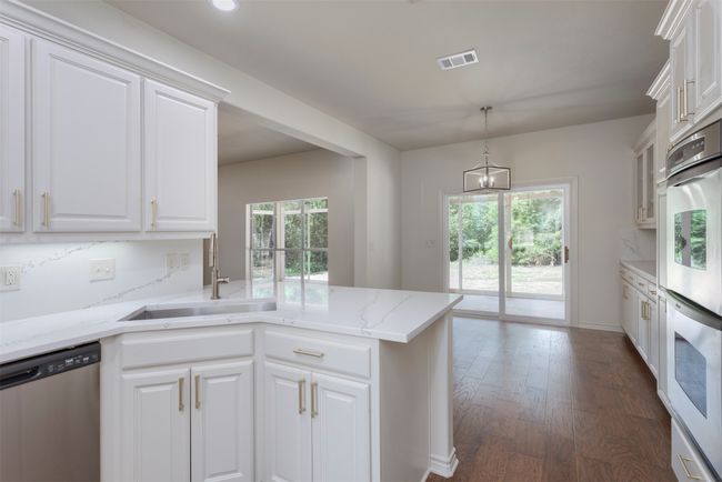 Kitchen featuring stainless steel appliances, a sink, white cabinetry, dark wood finished floors, and recessed lighting | Image 12