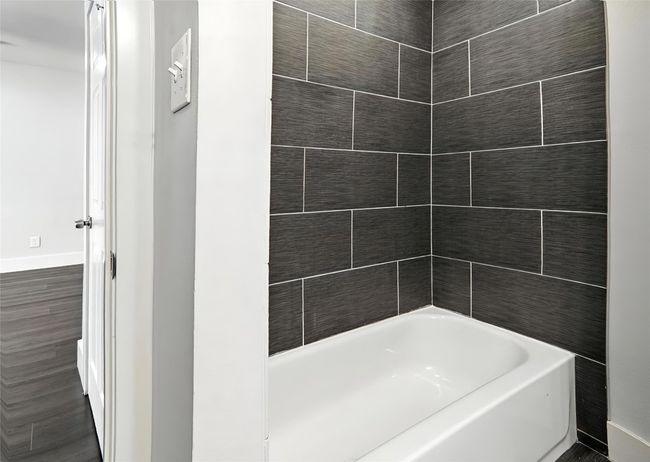 Full bathroom with baseboards and shower combination | Image 15