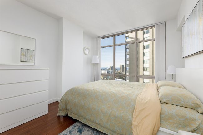 Bedroom with wood finished floors, a city view, and baseboards | Image 7