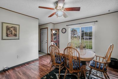 Dining space featuring ceiling fan, a textured ceiling, and wood-type flooring | Image 3