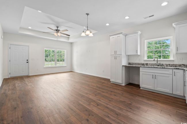 Kitchen with a sink, dark wood-style flooring, ceiling fan, plenty of natural light, and recessed lighting | Image 10