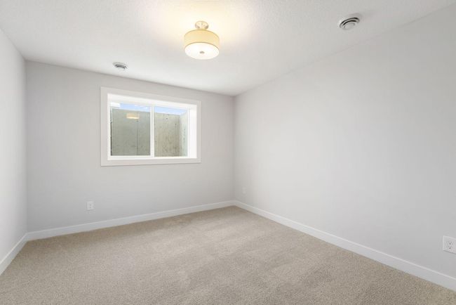This spacious basement bedroom #4 provides a peaceful retreat with ample space, large windows for natural light, and plenty of room for furniture, making it an ideal spot for rest and relaxation. | Image 35
