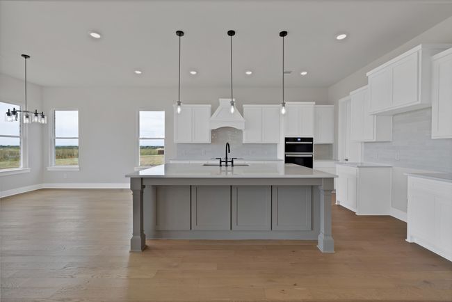 Kitchen featuring an island with sink, light wood-style flooring, backsplash, and recessed lighting | Image 10