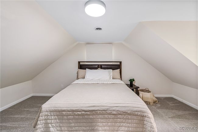 Bedroom with lofted ceiling, visible vents, carpet flooring, and baseboards | Image 13