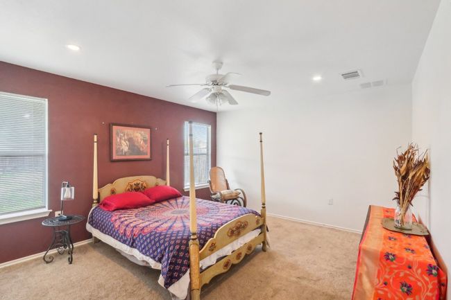 Bedroom featuring light colored carpet, a ceiling fan, and visible vents | Image 8