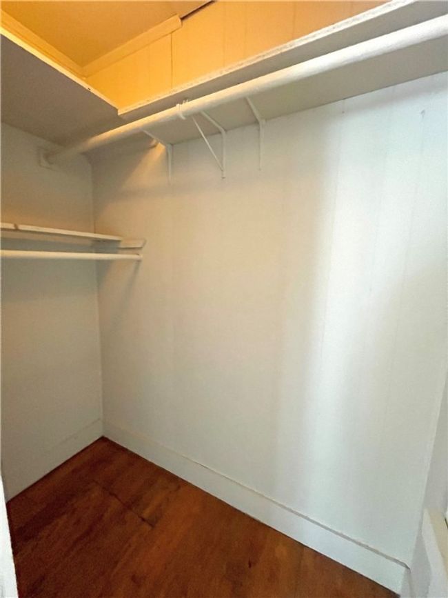 Walk in closet featuring dark wood finished floors | Image 8