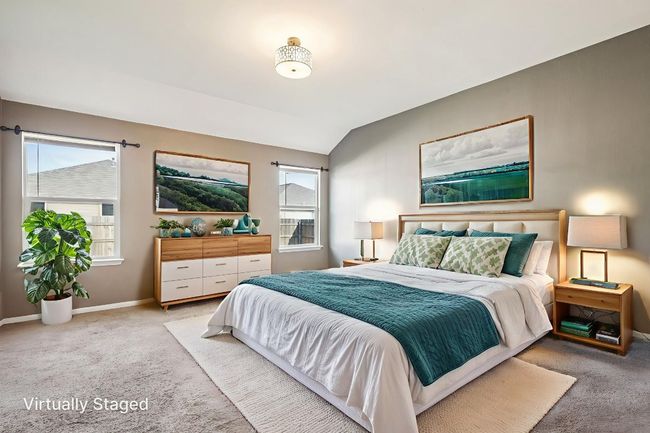 Bedroom featuring light colored carpet, multiple windows, and vaulted ceiling | Image 16