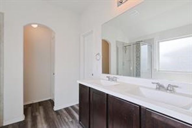 Full bath with double vanity, a stall shower, and wood finished floors | Image 10