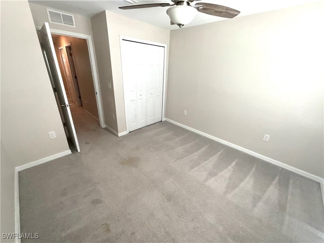 Unfurnished bedroom with carpet floors, a closet, and a ceiling fan | Image 16