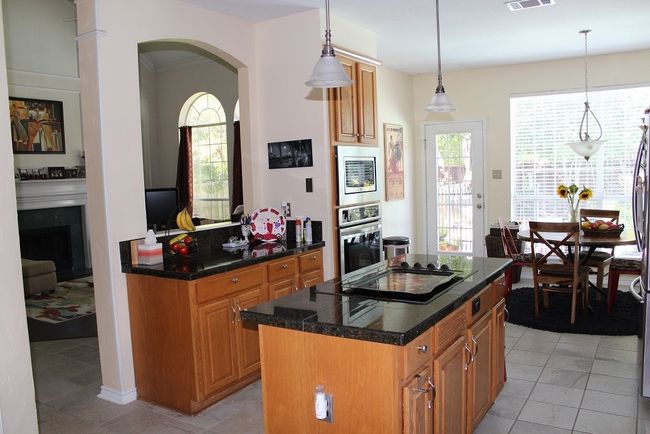 Kitchen with stainless steel appliances, arched walkways, a kitchen island, and plenty of natural light | Image 12