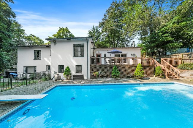 View of swimming pool featuring a fenced in pool, stairs, a deck, and fence | Image 45