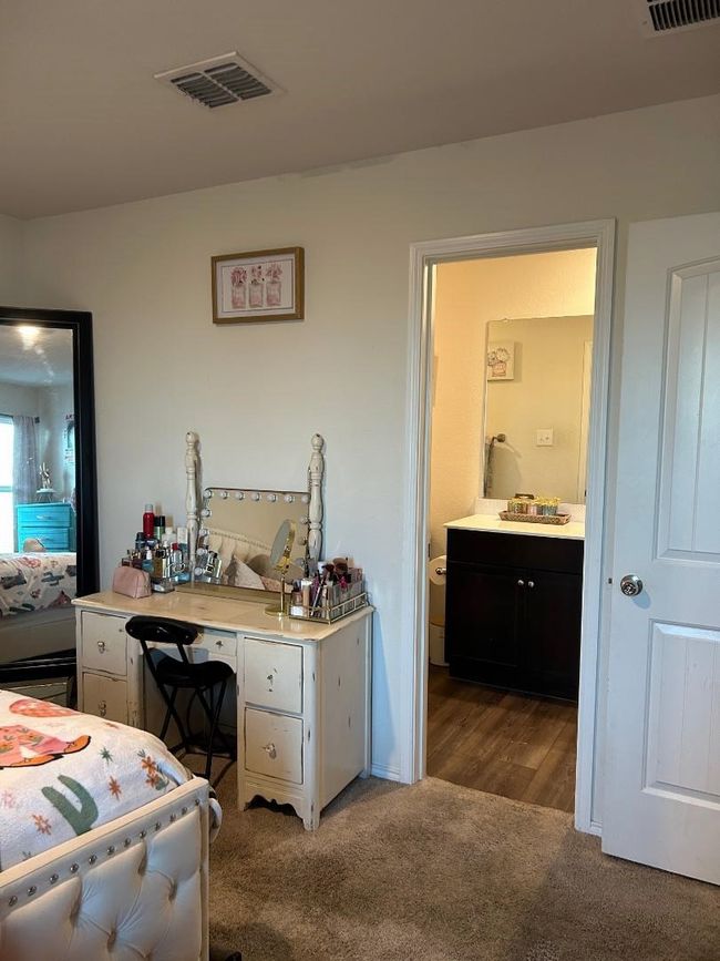 Primary bedroom has tan carpet flooring with adjointing bathroom. | Image 11