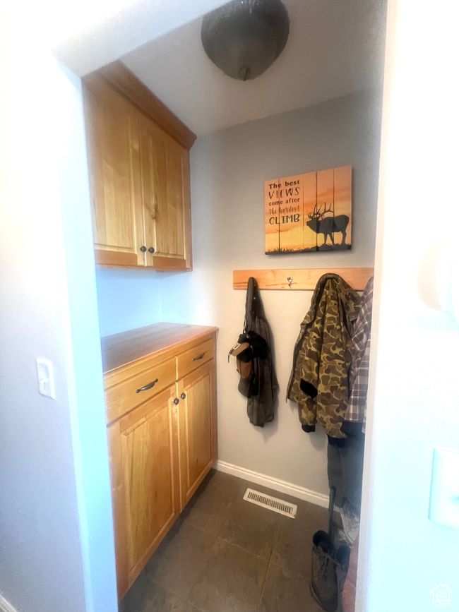 Mudroom featuring dark tile patterned floors, baseboards, and visible vents | Image 38