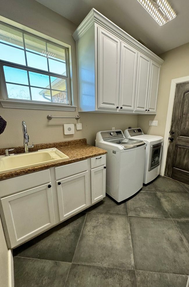 Washroom featuring a sink, cabinet space, and washer and clothes dryer | Image 11