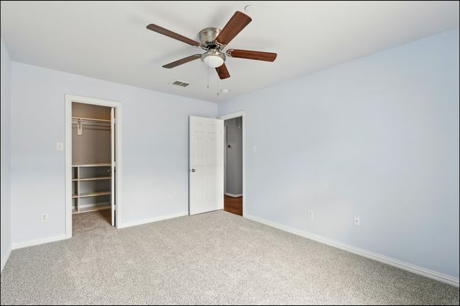 Unfurnished bedroom featuring a walk in closet, visible vents, carpet floors, baseboards, and a closet | Image 29