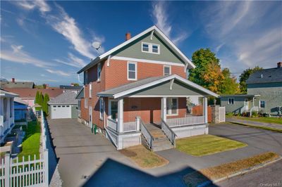 View of front of house with covered porch, an outdoor structure, and a garage | Image 2