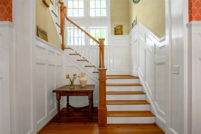 Stairs featuring a decorative wall, hardwood / wood-style flooring, wainscoting, and a towering ceiling | Image 14