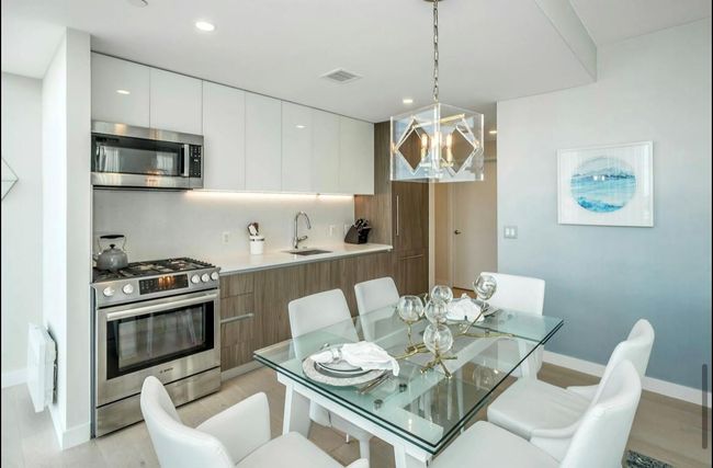 Dining room featuring light wood finished floors, a chandelier, and recessed lighting | Image 7