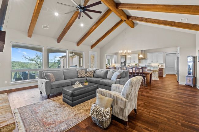 Living area featuring recessed lighting, visible vents, high vaulted ceiling, dark wood-style flooring, and ceiling fan with notable chandelier | Image 7