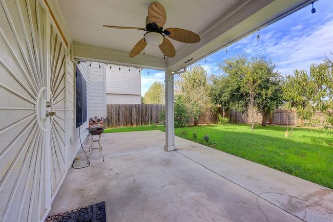 Fenced backyard featuring a patio and ceiling fan | Image 18
