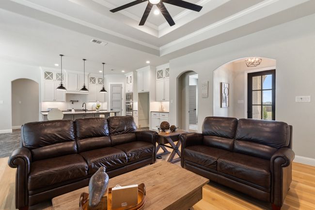 Living area with arched walkways, a ceiling fan, visible vents, and baseboards | Image 6
